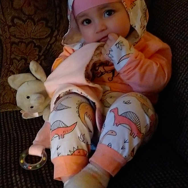 Megan is registered to the contest to win money with this photo: baby_toddler_clothing, child, comfort, companion_dog, doll, eye, face, fawn, foot, fur, happy, human_leg, lap, pink, skin, stuffed_toy, tail, thigh, toy, wood