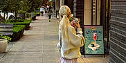 .bo joined the competition — help win amazing prizes! woman, cat, sidewalk, sunset, urban, street, pedestrian, building, bench, tree, sign, skirt, sneakers, blonde_hair, clothing, storefront, potted_plant, person, outdoor, evening
