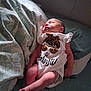 baby, newborn, sleeping, onesie, infant, bed, blanket, pillow, pattern, soft_light, peaceful, cute, clothing, rest, child, human, skin, small, indoors, lying_down