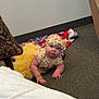 baby, blanket, carpet, child, clothing, crawling, curious, cute, electrical_outlet, floor, headband, indoor, infant, looking_up, patterned_chair, person, toddler, tutu, wall, yellow