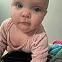 Taylor is registered to the contest to win money with this photo: baby, bed, blue_eyes, child, close_up, colorful, crawling, curious, cute, expression, face, indoor, infant, person, pink_clothing, purse, skin, soft_light, toy, young