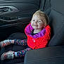 child, toddler, smiling, car, car_interior, jacket, red_jacket, purple_lining, leggings, floral_pattern, shoes, silver_shoes, seat, seatbelt, window, door, happy, person, cute, young_child