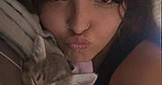 Pebbles is registered to the contest to win money with this photo: woman, person, cat, kitten, selfie, portrait, face, kiss, puckered_lips, sleeping, striped_fur, pet, pink_harness, indoor, cuddling, closeup, long_hair, nose_ring, casual, vertical_photo
