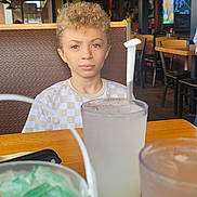 Colin a rejoint le concours — aidez-le/la à gagner de superbes lots ! beverage, boy, child, cup, diningtable, face, furniture, head, helmet, indoors, juice, lamp, lemonade, male, person, photography, portrait, restaurant, table, wood