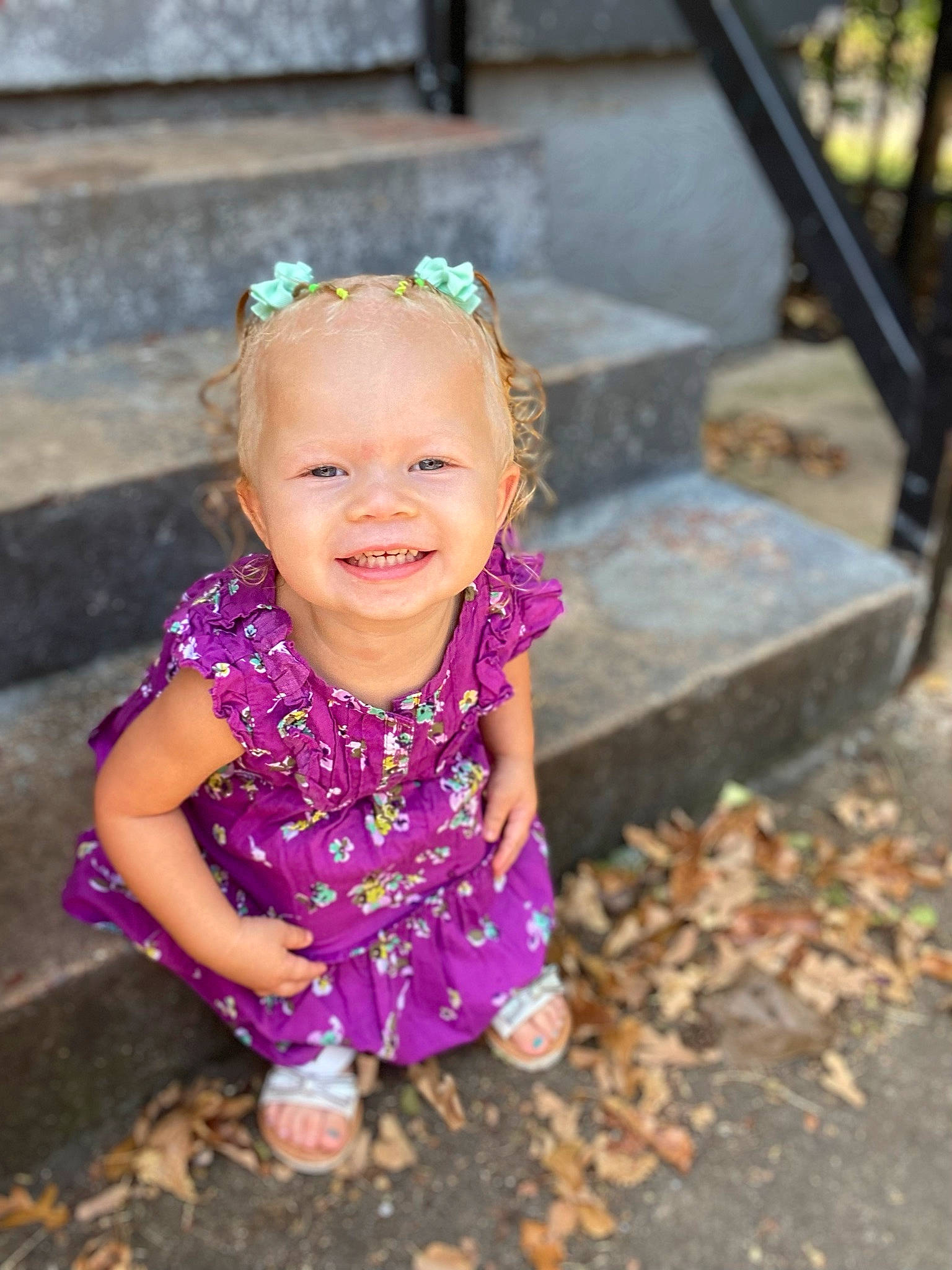 Amalie is registered to the contest to win money with this photo: arm, baby_toddler_clothing, chin, dress, eye, facial_expression, hair, hairstyle, hand, happy, head, iris, joy, leaf, mouth, people_in_nature, person, pink, purple, skin