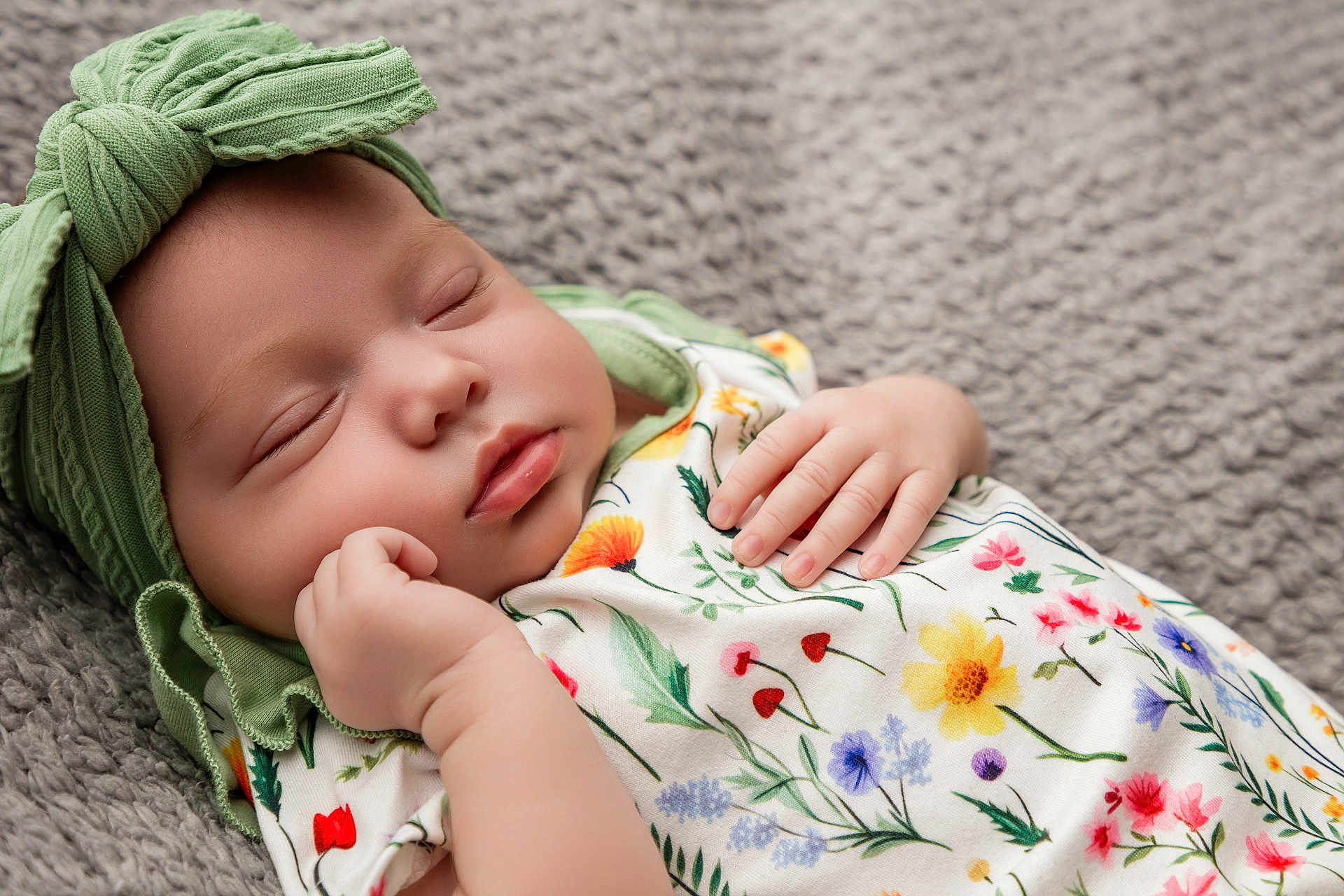 Amara is registered to the contest to win money with this photo: baby, sleeping, infant, headwrap, green, floral_pattern, clothing, soft_blanket, peaceful, closeup, cute, newborn, hand, face, skin, child, portrait, resting, indoors, cozy