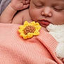 baby, sleeping, blanket, knitted, flower, crocheted, sunflower, plush_toy, soft, cute, peaceful, child, face, skin, hand, lips, closeup, cozy, rest, comfort