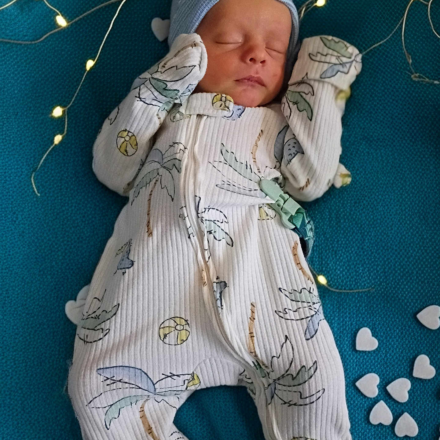 Leland Matthew is registered to the contest to win money with this photo: baby, blanket, closeup, cozy, cute, decorative_hearts, fairy_lights, hat, heart_confetti, infant, mittens, newborn, nursery, onesie, pajamas, peaceful, portrait, sleeping, soft_lighting, teal_background