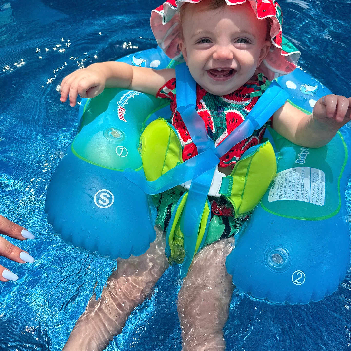 Evalynn is registered to the contest to win money with this photo: baby, clothing, face, hat, head, leisureactivities, lifejacket, outdoors, person, photography, pool, portrait, sport, summer, swimming, swimmingpool, swimwear, vest, water, watersports