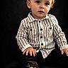 toddler, child, portrait, striped_shirt, black_pants, shoe, sole, sitting, curious_eyes, indoor, studio, fashion, cute, young_child, hands, face, clothing, footwear, expression, background