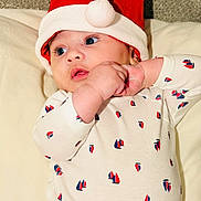 Adam a rejoint le concours — aidez-le/la à gagner de superbes lots ! baby, infant, santa_hat, onesie, red, white, blue, sailboat_pattern, cute, holiday, christmas, soft, pillow, lying_down, chubby_hands, face, eyes, indoor, portrait, child