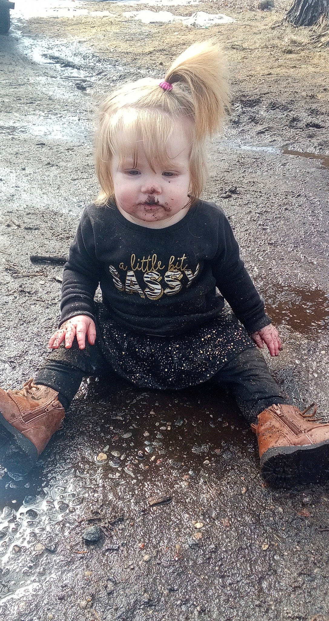 Audrianna is registered to the contest to win money with this photo: asphalt, baby_toddler_clothing, blond, cool, eye, fun, grass, happy, iris, pattern, people_in_nature, person, road_surface, sitting, sleeve, smile, soil, standing, t_shirt, toddler