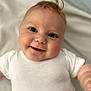 Alfie is registered to the contest to win money with this photo: baby, baby_girl, child, close_up, cute, face, happy, head, human, indoor, infant, lying_down, onesie, person, portrait, skin, smiling, soft_background, white_clothing, young_child