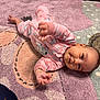 Kensie joined the competition — help win amazing prizes! baby, infant, pink_onesie, carpet, patterned_rug, child, floor, cute, smiling, reaching_hand, head, earrings, indoor, young_child, lying_down, playful, soft_texture, home, cozy, adorable