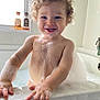 toddler, child, bathtub, bubbles, foam, bath, curly_hair, smiling, happy, water, skin, window, soap, bubble_beard, hands, bathroom, sink, faucet, light, cute