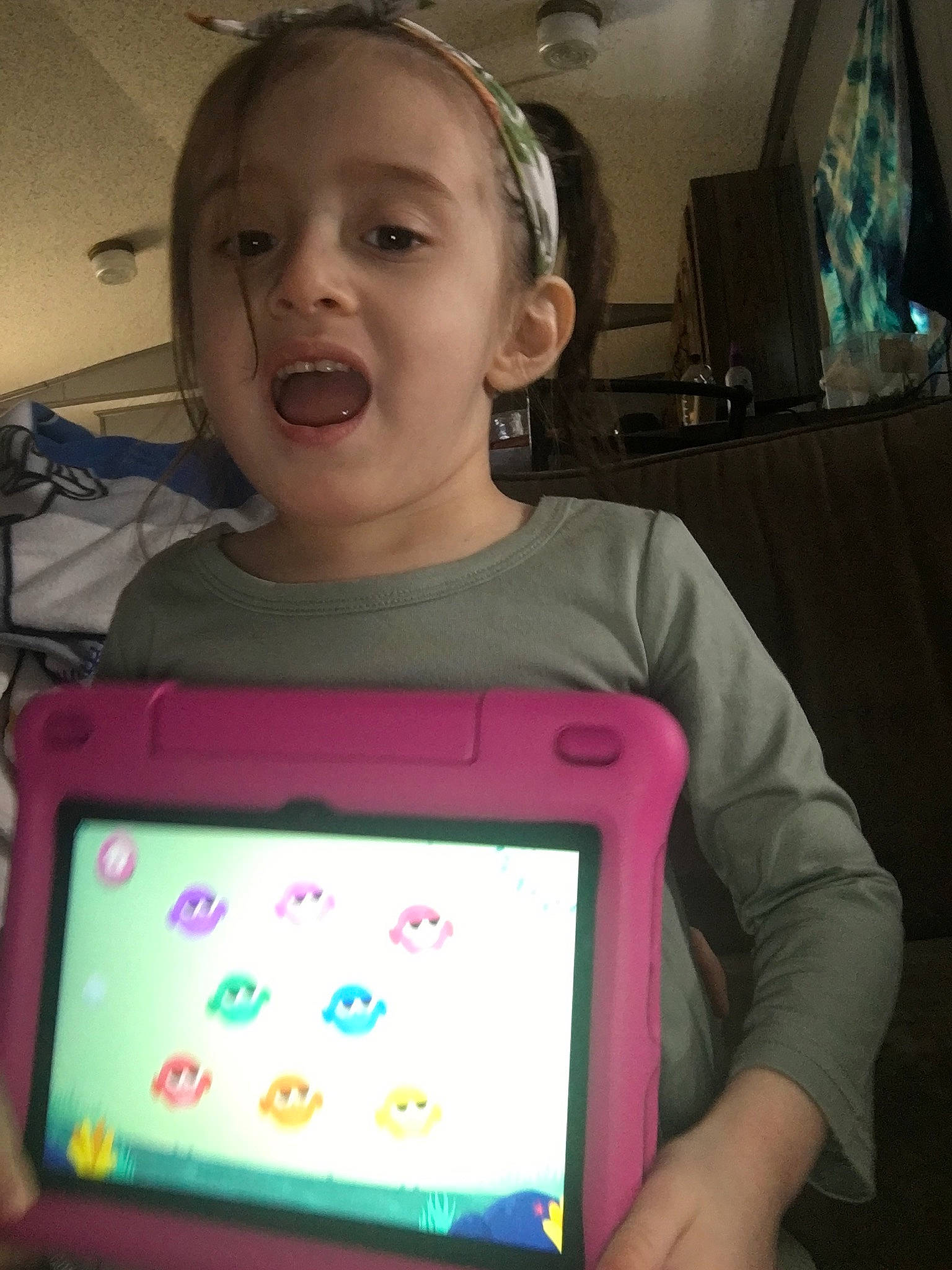 Shelby is registered to the contest to win money with this photo: audio_equipment, child, display_device, electronic_device, event, fun, gadget, happy, headphones, hearing, magenta, person, pink, purple, rectangle, room, sweetness, t_shirt, tablet_computer, technology