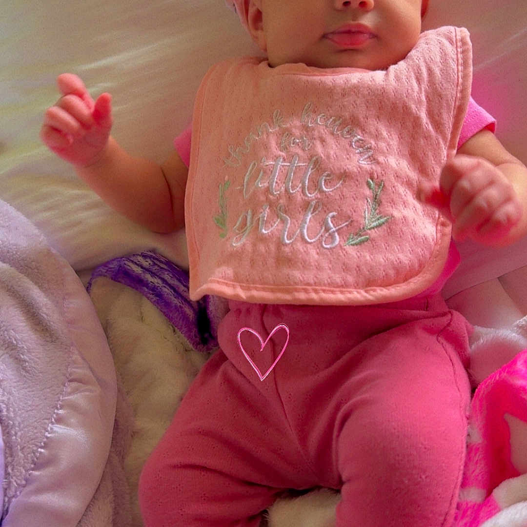 Xureila is registered to the contest to win money with this photo: baby, infant, pink_clothing, headband, bow, bib, blanket, bed, soft_toys, cute, child, portrait, indoors, cozy, sleepwear, feet, hands, face, expression, relaxing