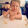 toddler, child, high_chair, food, crumbs, indoor, face, expression, hands, tray, water_bottle, terrarium, furniture, home, person, messy, contemplative, blue_eyes, short_hair, napkin