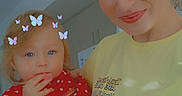 Echo is registered to the contest to win money with this photo: woman, child, toddler, indoor, butterflies, red_dress, yellow_shirt, smile, face, hair, blue_eyes, holding, cute, portrait, family, playful, filter, home, light, casual
