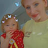 woman, child, toddler, indoor, butterflies, red_dress, yellow_shirt, smile, face, hair, blue_eyes, holding, cute, portrait, family, playful, filter, home, light, casual