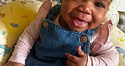 Sevyn joined the competition — help win amazing prizes! baby, child, denim_overalls, pink_shirt, bow, smile, thumbs_up, unicorn_cushion, colorful, cute, happy, indoors, portrait, sitting, face, human, infant, clothing, playful, headwear