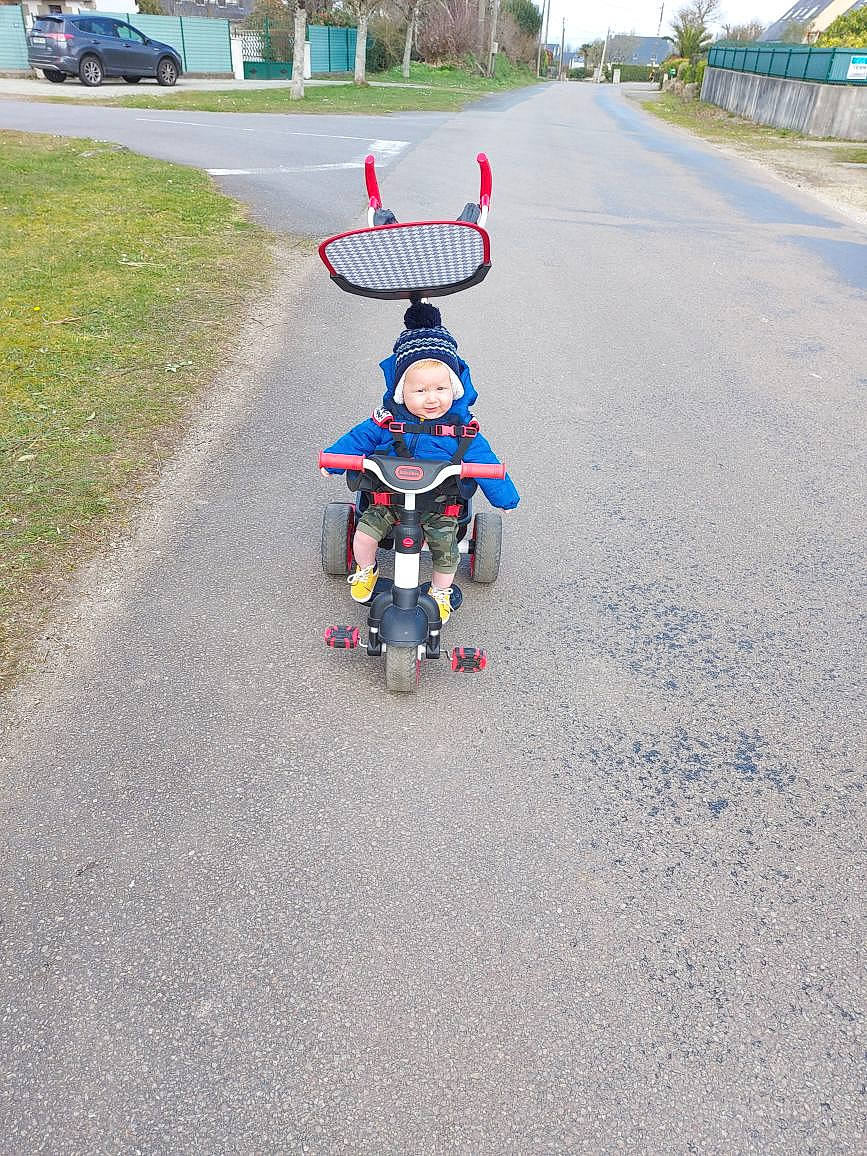 Evan a rejoint le concours — aidez-le/la à gagner de superbes lots ! asphalt, baby, baby_carriage, bicycle_accessory, cycling, grass, headwear, motor_vehicle, person, plant, recreation, riding_toy, road, road_surface, rolling, sidewalk, sky, tire, toddler, tree