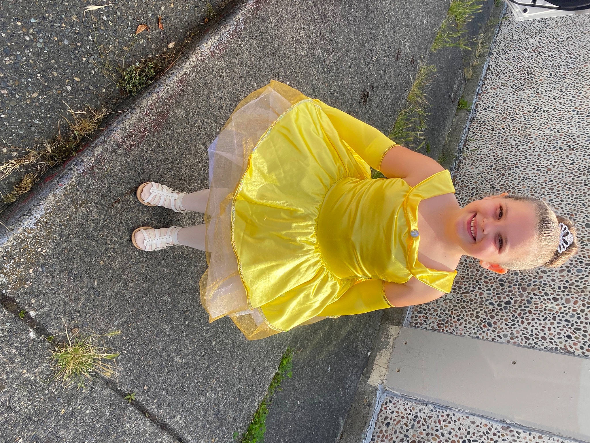 Karma is registered to the contest to win money with this photo: asphalt, baby_toddler_clothing, child, concrete, curb, fun, grass, hat, human_leg, joy, person, road, road_surface, sandal, shadow, sidewalk, smile, street_fashion, tar, thigh