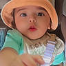 apparel, attention, baby, car_seat, child, close_up, clothing, curious, cute, expression, eyes, face, hand, hat, indoors, infant, person, portrait, seatbelt, young_child