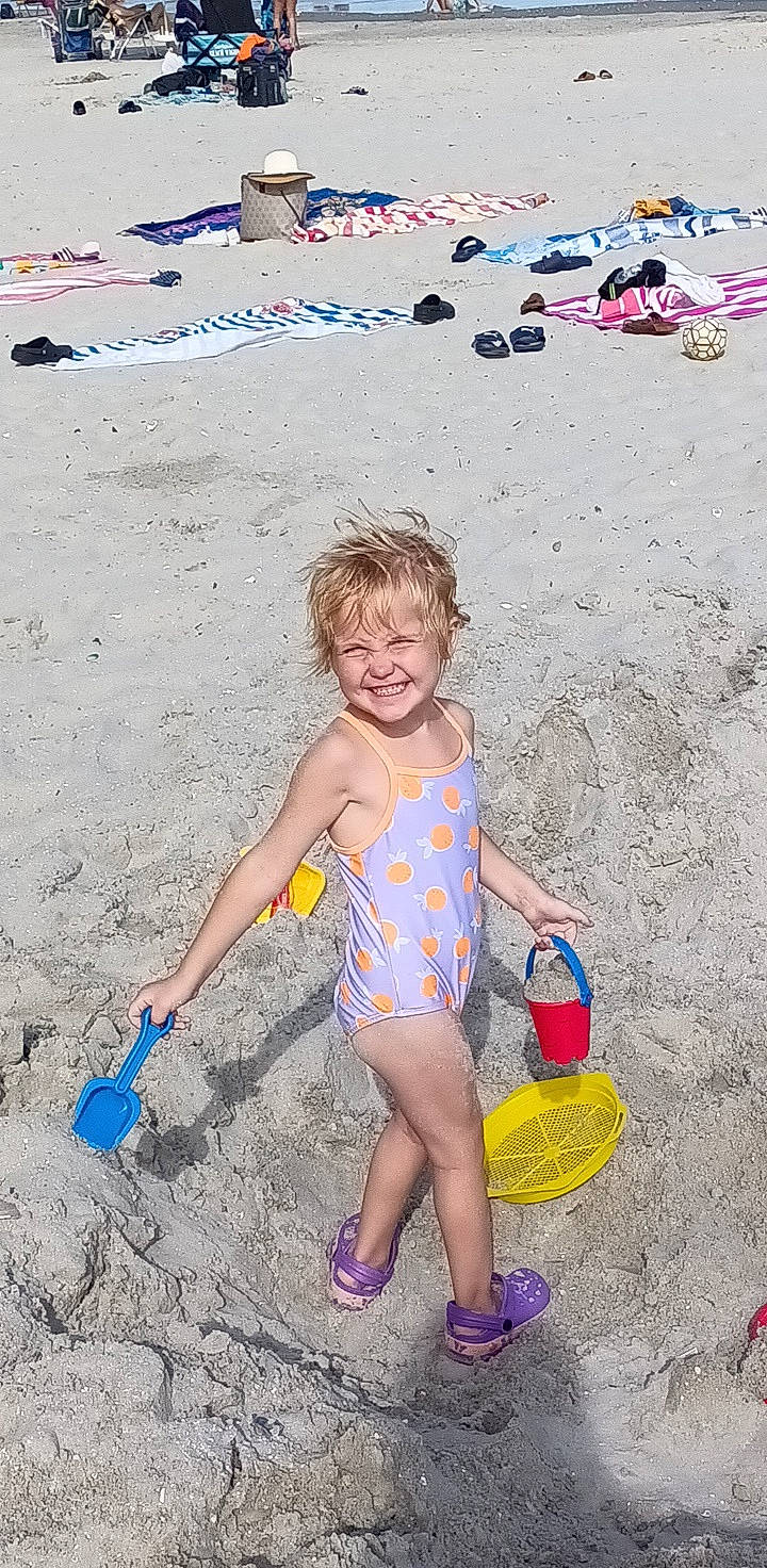 Kylie joined the competition — help win amazing prizes! barefoot, beach, body_of_water, child, foot, fun, happy, human_leg, joy, leisure, people_in_nature, people_on_beach, person, play, recreation, sand, shorts, sitting, smile, summer
