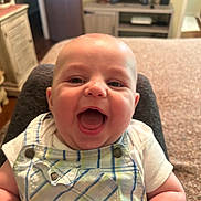 Lennox joined the competition — help win amazing prizes! baby, child, smiling, happy, indoor, plaid_overall, white_shirt, face, head, person, furniture, cabinet, door, room, decor, sitting, skin, expression, portrait, cheerful