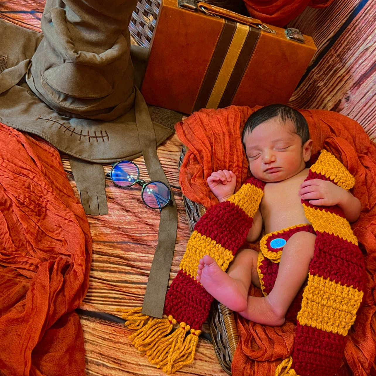 Axton S Maharaj joined the competition — help win amazing prizes! baby, basket, child, cozy, cute, glasses, indoor, infant, knitted_scarf, newborn, orange_fabric, peaceful, portrait, resting, sleeping, soft_texture, vintage_suitcase, warm_colors, wizard_hat, wooden_floor