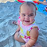 baby, child, sand, beach, swimsuit, smile, happy, towel, watermelon_pattern, summer, sunny, playful, cute, sitting, barefoot, person, fun, vacation, outdoor, family