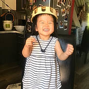 Josie Ha An participe au concours pour gagner de l'argent avec cette photo : toddler, child, smiling, helmet, striped_dress, chair, kitchen, refrigerator, photos, appliances, indoor, happy, person, shorts, wooden_floor, cabinet, staircase, family, home, joy