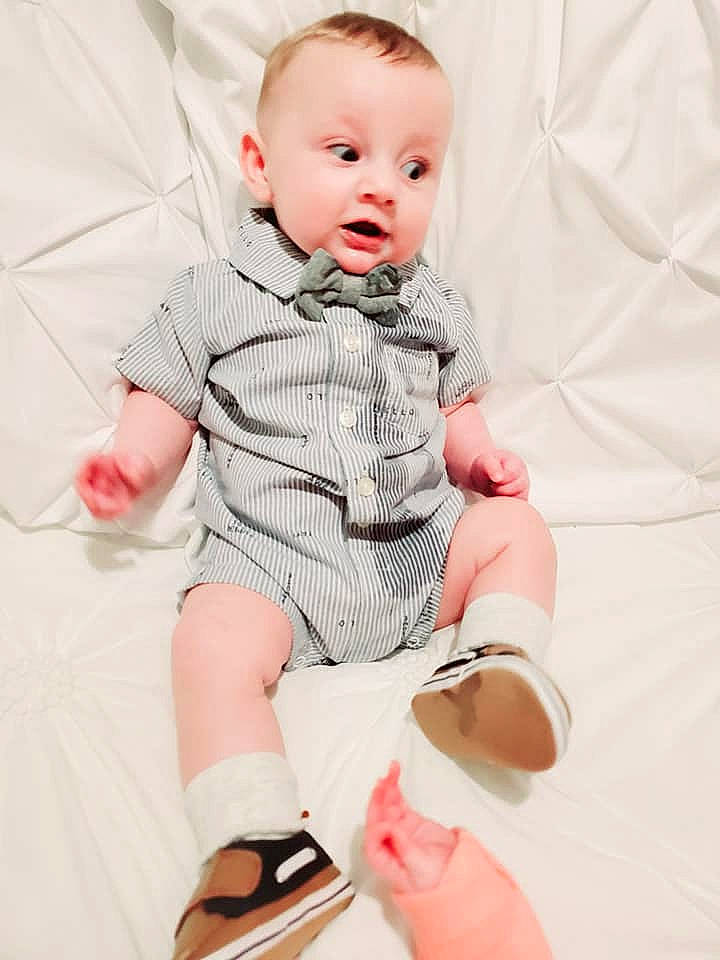 Alec is registered to the contest to win money with this photo: baby, baby_products, baby_toddler_clothing, child, child_model, leg, person, photography, pink, product, shoe, sitting, skin, sleeve, surprise, toddler