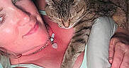 Ms. Kitty joined the competition — help win amazing prizes! woman, cat, tabby_cat, sleeping, resting, indoor, bed, blanket, comfort, relaxation, human, pet, animal, skin, face, hand, necklace, light, closeup, casual_clothing