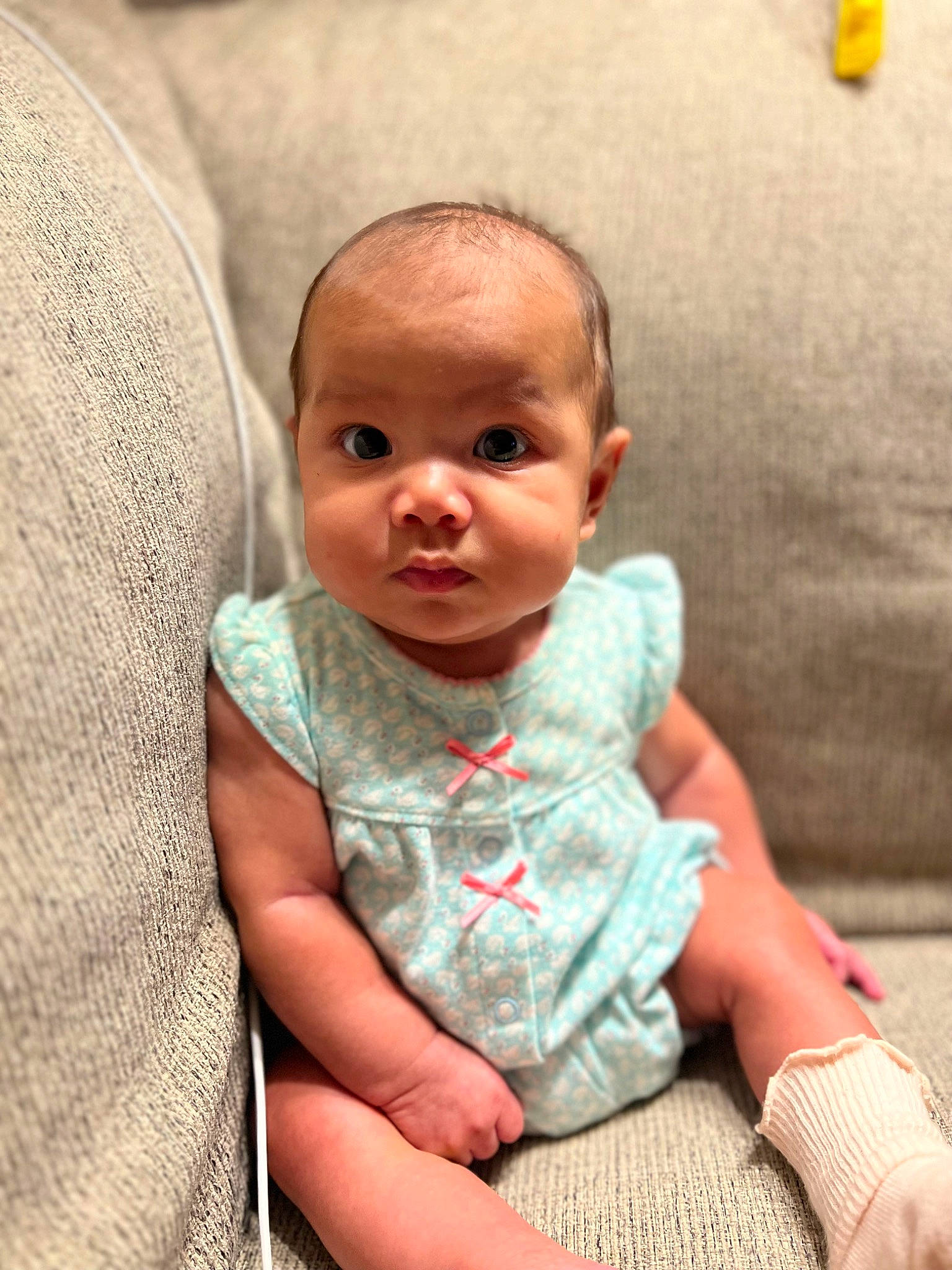 Emilia is registered to the contest to win money with this photo: baby, baby_toddler_clothing, cheek, child, comfort, eye, eyelash, finger, fun, gesture, happy, iris, linens, lip, mouth, nose, person, sitting, skin, sleeve