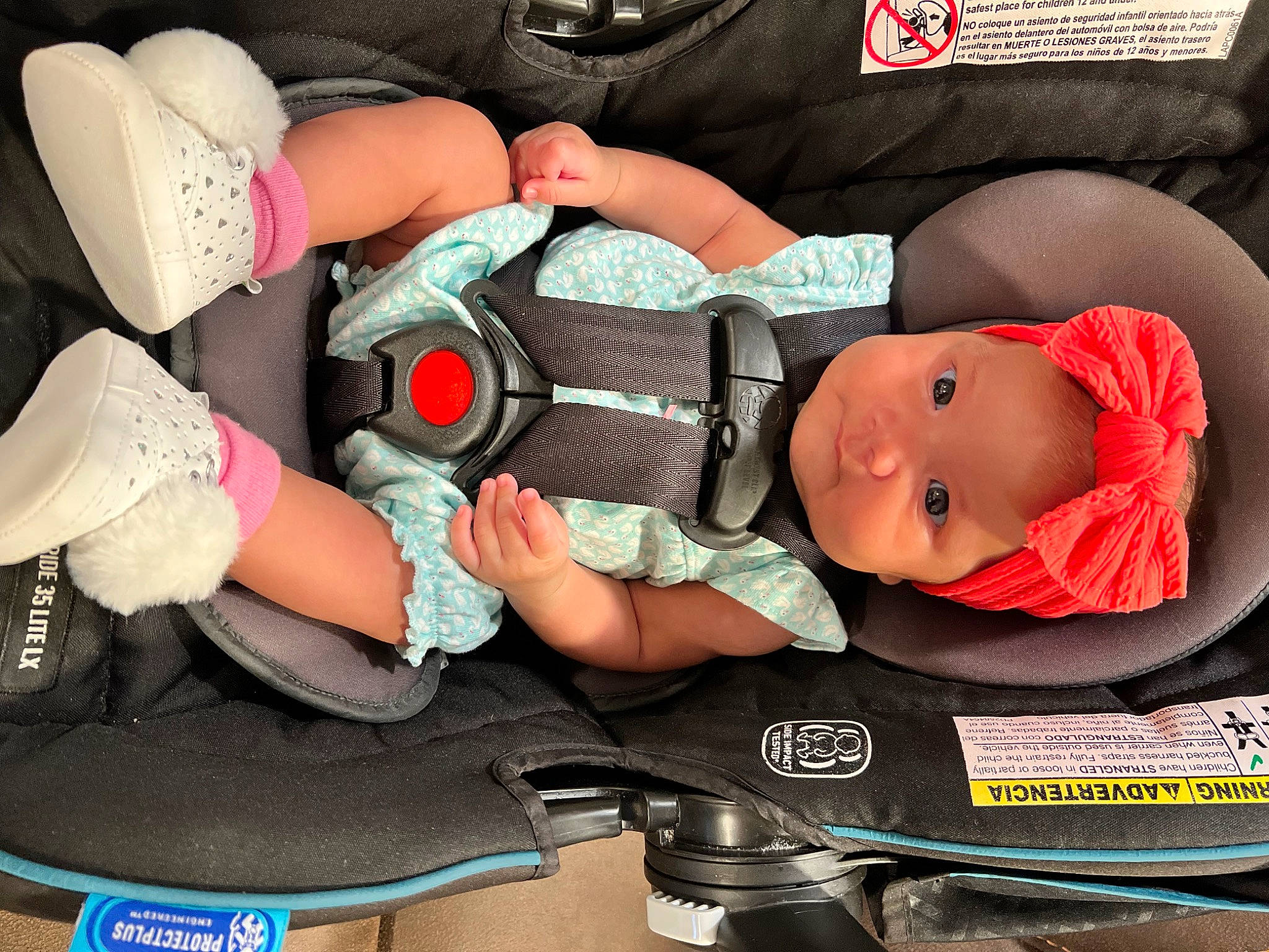 Emilia is registered to the contest to win money with this photo: arm, auto_part, baby, baby_carriage, baby_products, baby_safety, baby_toddler_clothing, car_seat, carmine, child, comfort, hat, headwear, human_body, human_leg, mouth, nail, person, personal_protective_equipment, product