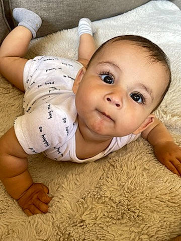 Beaux is registered to the contest to win money with this photo: baby, baby_toddler_clothing, cheek, comfort, eye, flooring, gesture, hand, happy, head, human_body, leg, mouth, nose, person, skin, sleeve, smile, thumb, toddler