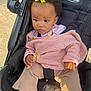 Seven joined the competition — help win amazing prizes! beige_pants, black_stroller, casual, child, clothing, curly_hair, expression, face, food, footwear, hand, outdoor, person, pink_sweater, portrait, seatbelt, stroller, sunlight, toddler, yellow_bow