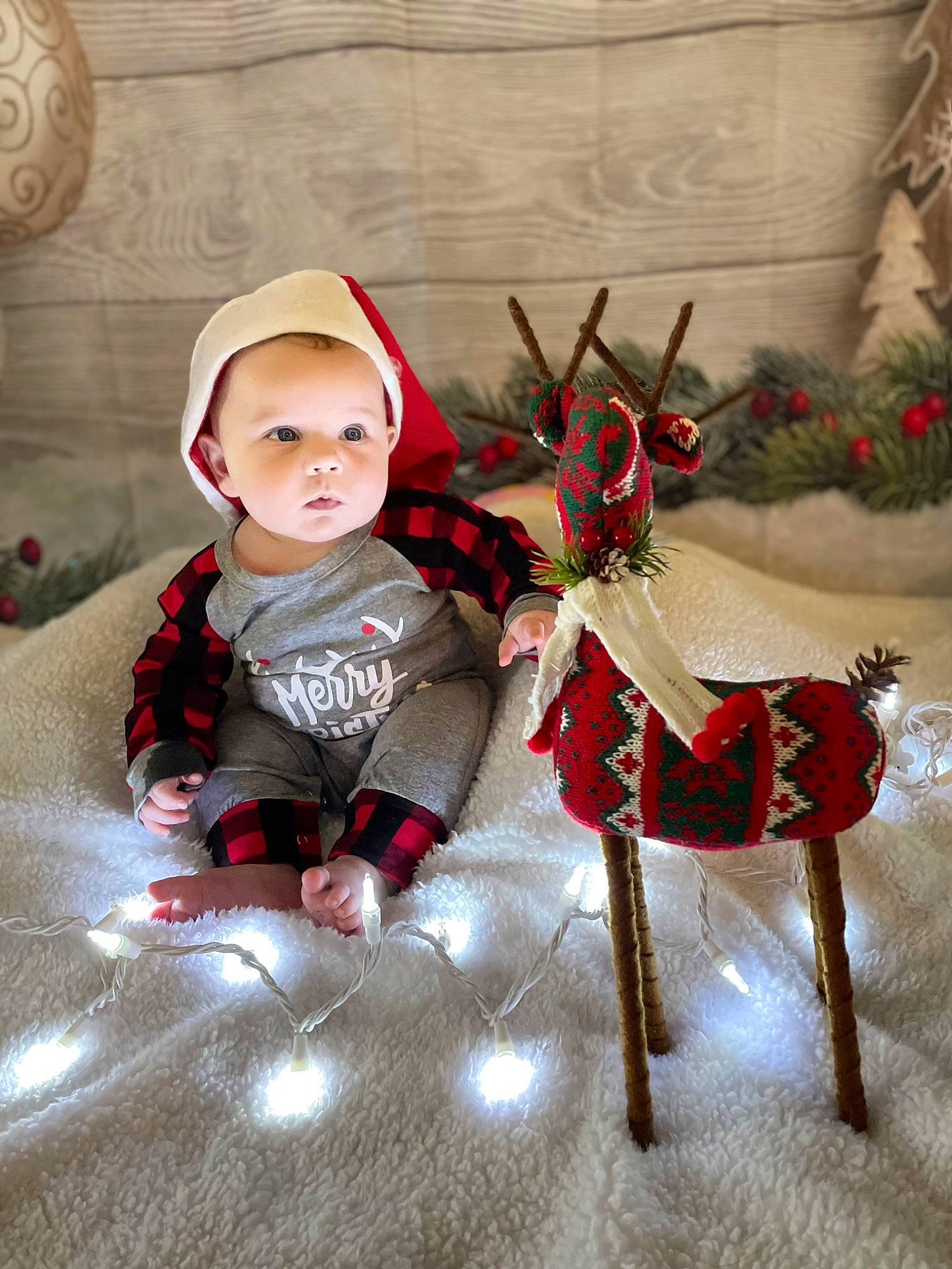 Theo is registered to the contest to win money with this photo: baby, baby_toddler_clothing, carmine, child, christmas, christmas_eve, christmas_ornament, costume, costume_hat, event, fashion_accessory, fictional_character, flooring, hat, person, sitting, sleeve, sun_hat, toddler, twig