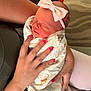 newborn, baby, blanket, bow, headband, hand, nail_polish, tattoo, arm, person, sleeping, cozy, animal_print, pink, cute, infant, indoor, soft, wrapped, cradled