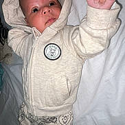 Myllan participe au concours pour gagner de l'argent avec cette photo : baby, bed, child, clothing, cozy, cute, expression, fabric, face, hand, hoodie, infant, lying_down, pajamas, person, portrait, sleepwear, soft, white_background, young