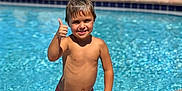 Preston joined the competition — help win amazing prizes! background, blue, boy, child, daytime, happy, holiday, lounge_chair, outdoor, pool, recreation, skin, smile, summer, sunny, swim_trunks, swimming, thumbs_up, water, wet_hair