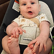 Landon Charles joined the competition — help win amazing prizes! baby, infant, child, feet, hands, babybjorn, carrier, toy, colorful, indoor, furniture, expression, curious, seated, clothing, onesie, face, person, footwear, home