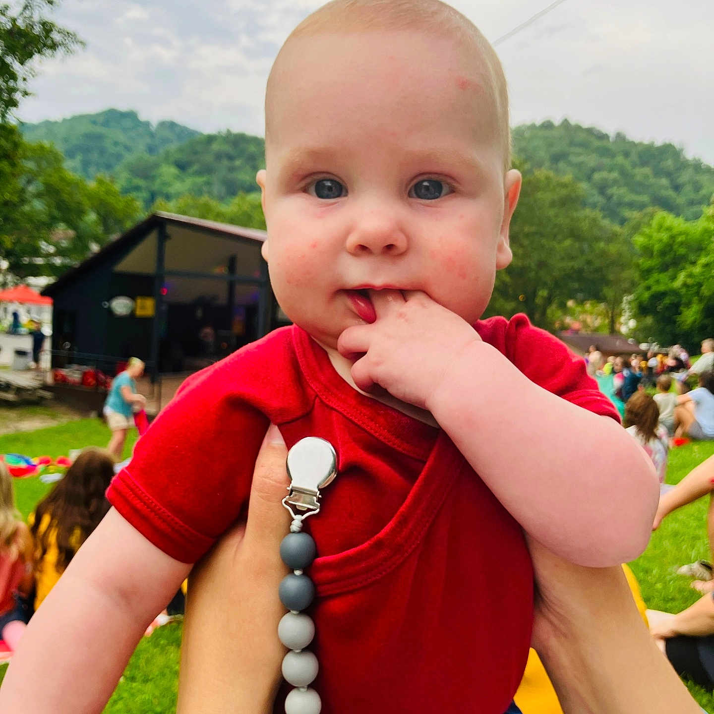 Landon Charles joined the competition — help win amazing prizes! baby, building, child, cute, daylight, face, fingers, grass, hand, hill, holding, infant, nature, outdoor, people, person, portrait, red_shirt, skin, trees