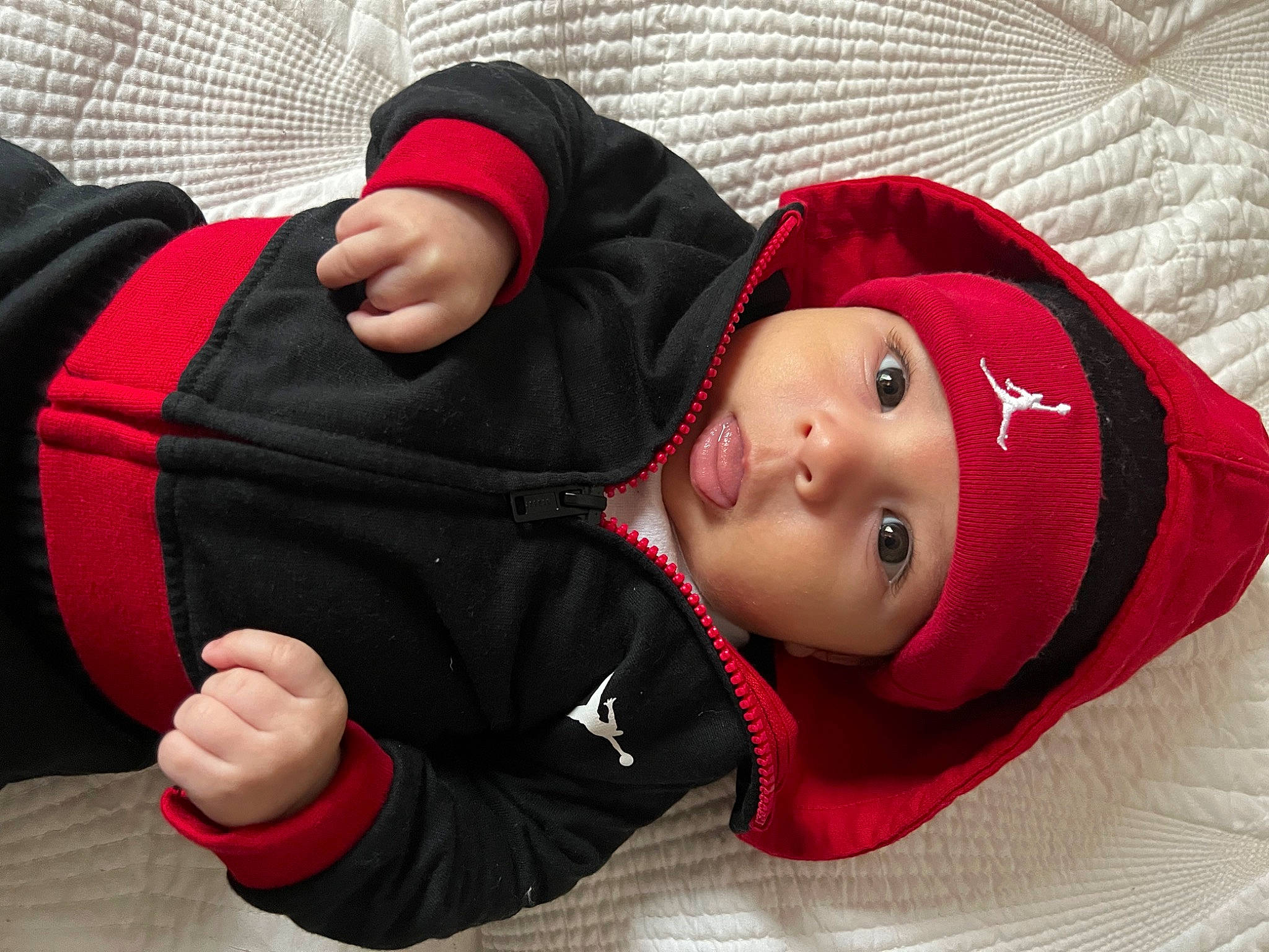 Ace is registered to the contest to win money with this photo: baby, baby_toddler_clothing, carmine, cheek, child, comfort, cool, fur, gesture, headwear, hood, jacket, outerwear, person, polar_fleece, portrait_photography, sitting, sleeve, smile, thumb