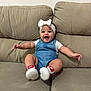 Isabella joined the competition — help win amazing prizes! arms_outstretched, baby, bow, child, comfortable, couch, cute, denim_overalls, footwear, happy, headband, indoor, infant, nike_shoes, person, portrait, sitting, smiling, white_shirt, young_child