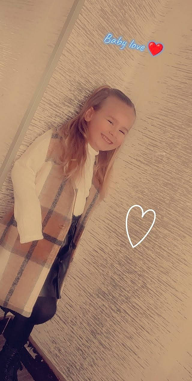 Amelya participe au concours pour gagner de l'argent avec cette photo : blond, child, cool, facial_expression, finger, flooring, font, gesture, hand, happy, human_body, joy, long_hair, material_property, pattern, person, sleeve, smile, standing, t_shirt