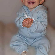 Tyler participe au concours pour gagner de l'argent avec cette photo : baby, child, smiling, happy, clapping, blue_hoodie, sitting, cozy, infant, cute, toothy_smile, hands, feet, socks, indoor, portrait, young_child, joyful, expression, soft_background