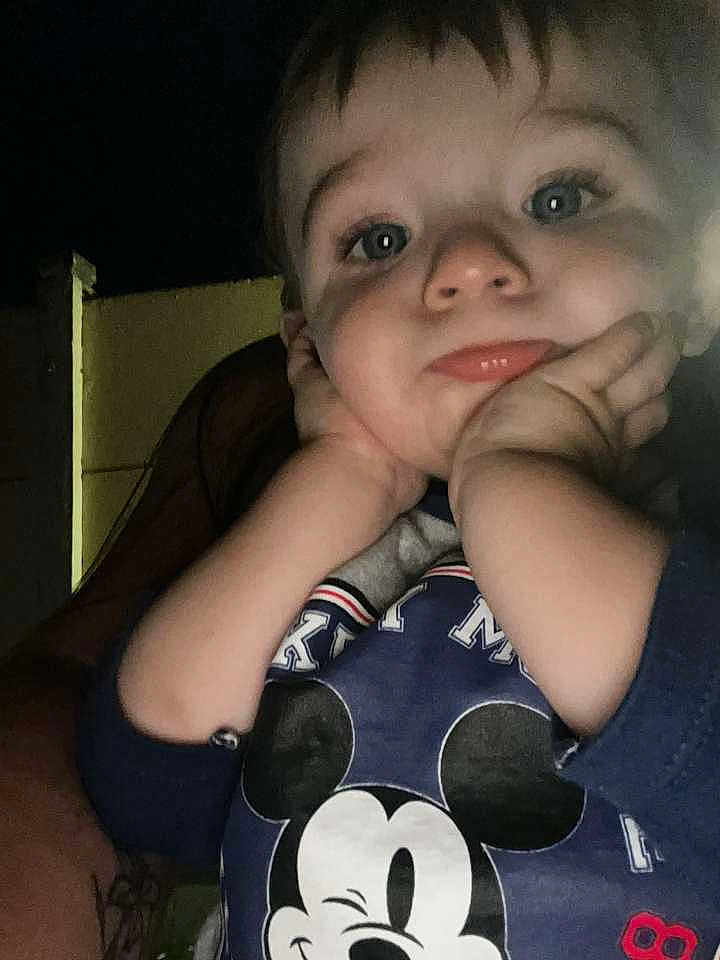 Tyler participe au concours pour gagner de l'argent avec cette photo : toddler, child, face, hands, blue_eyes, mickey_mouse, sweatshirt, clothing, portrait, closeup, expression, cute, indoor, young_child, person, baby, pout, casual, soft_light, dark_background